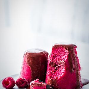 A raspberry red pudding shaped dessert with chocolate.