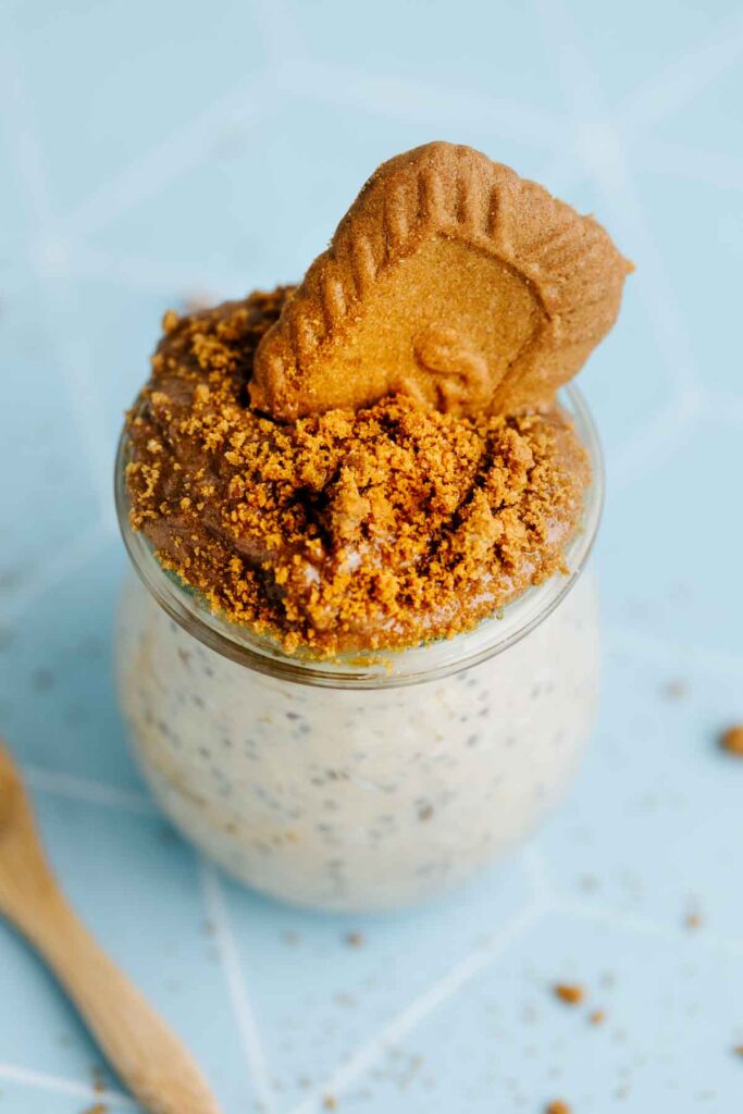 Lotus Biscoff Overnight Oats in a small glass jar with Lotus Biscoff spread, cookie crumbs and a Lotus Biscoff cookie as a topping.