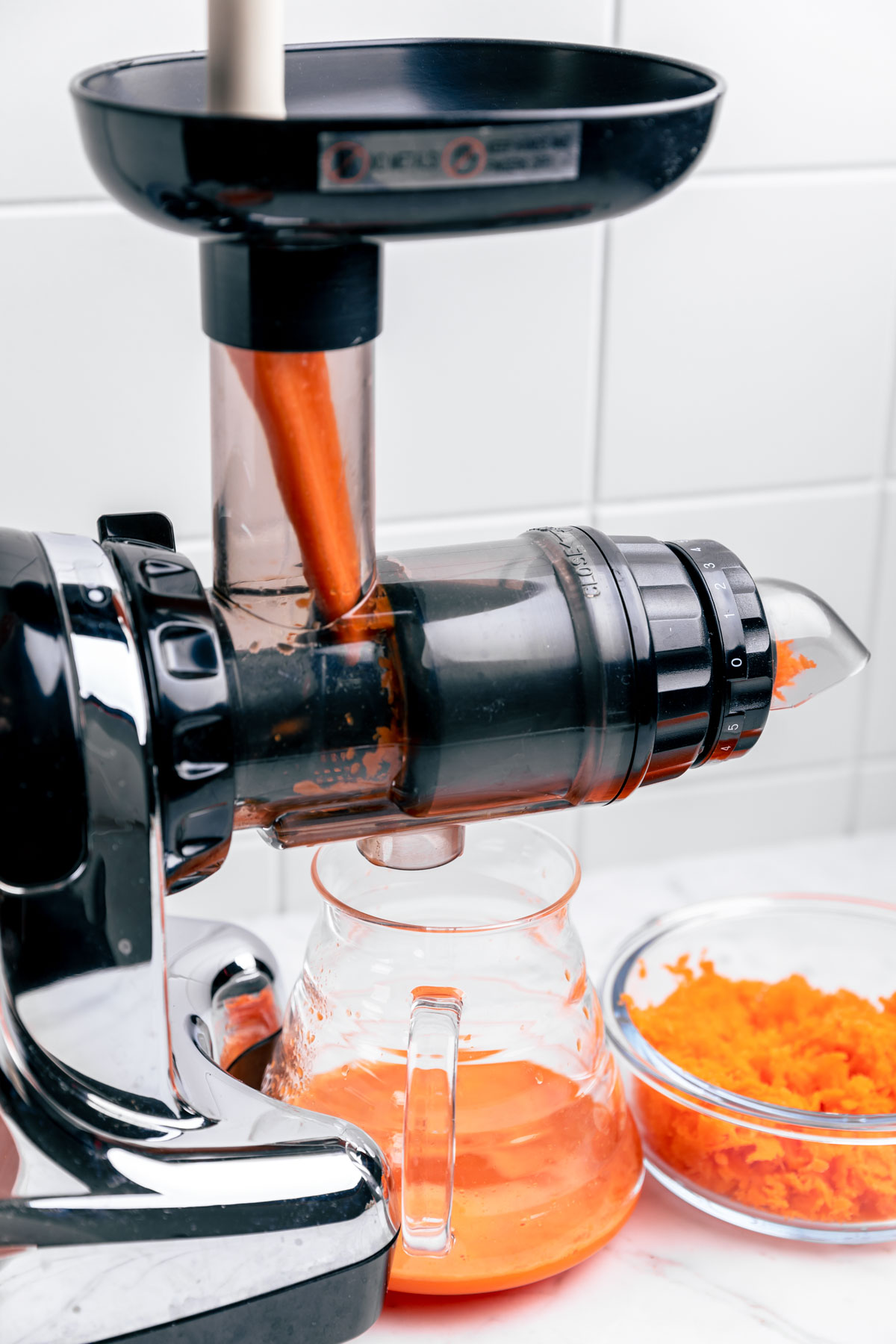 a horizontal juicer with a piece of carrot in the juicer