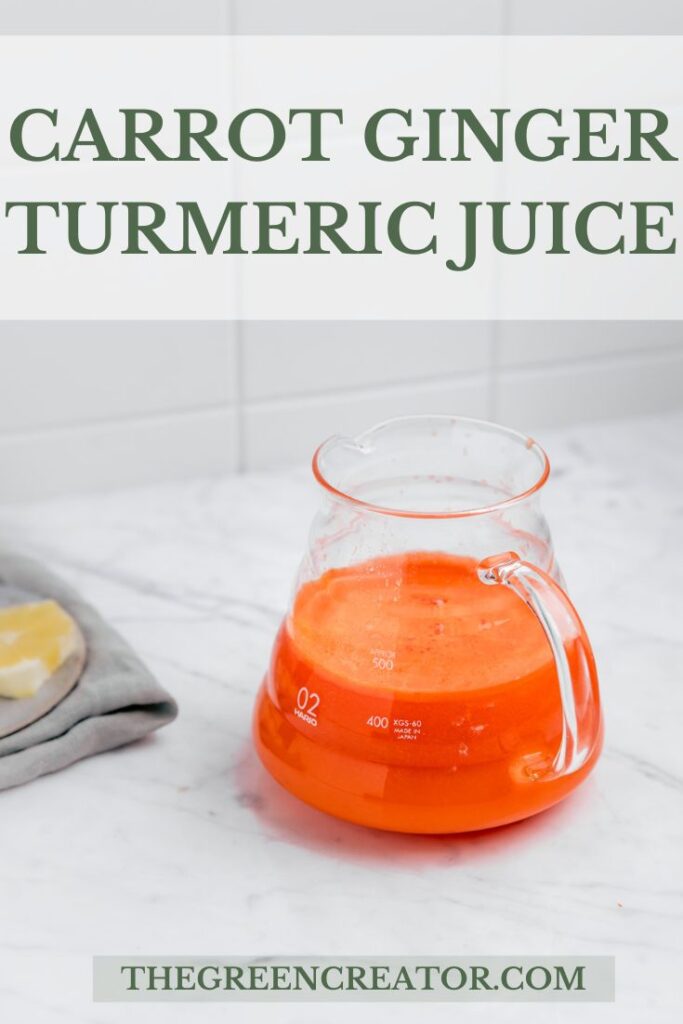 Carrot Ginger Turmeric Juice in a glass with a handle on a white marble table with a tiled white background