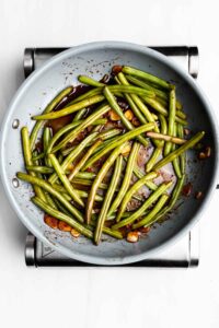 showing how to cook green beans in a pan