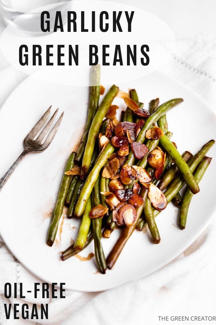 garlicky green beans on a white plate with a fork