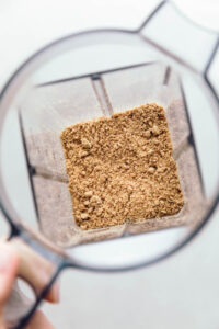 The top view of a blender with ground flaxseeds on the bottom.