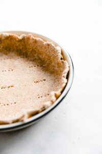 pie crust in a pie plate with a blue border from the side