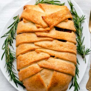 baked vegan wellington on a white plate with rosemary