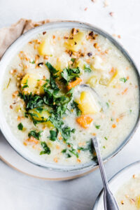 close up photo of cooked potato soup with silver spoon