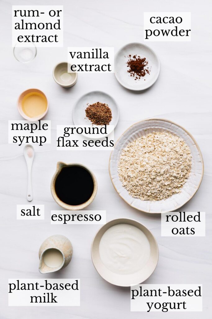 Ingredients for tiramisu overnight oats in small bowls on a white backdrop