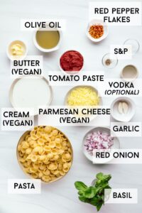 All the ingredients for Gigi Hadid pasta on a white backdrop in several small and medium sized bowls with the name of the ingredients in bold next to the bowls.