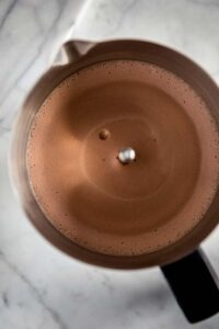 Frothed vegan chocolate milk in a milk frother