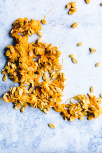 Pumpkin seeds and strings on a blue backdrop