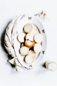 baked gingerbread bites on an oval white plate on a white backdrop with a light brown napkin