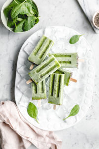 green popsicles on white plate with green leaves