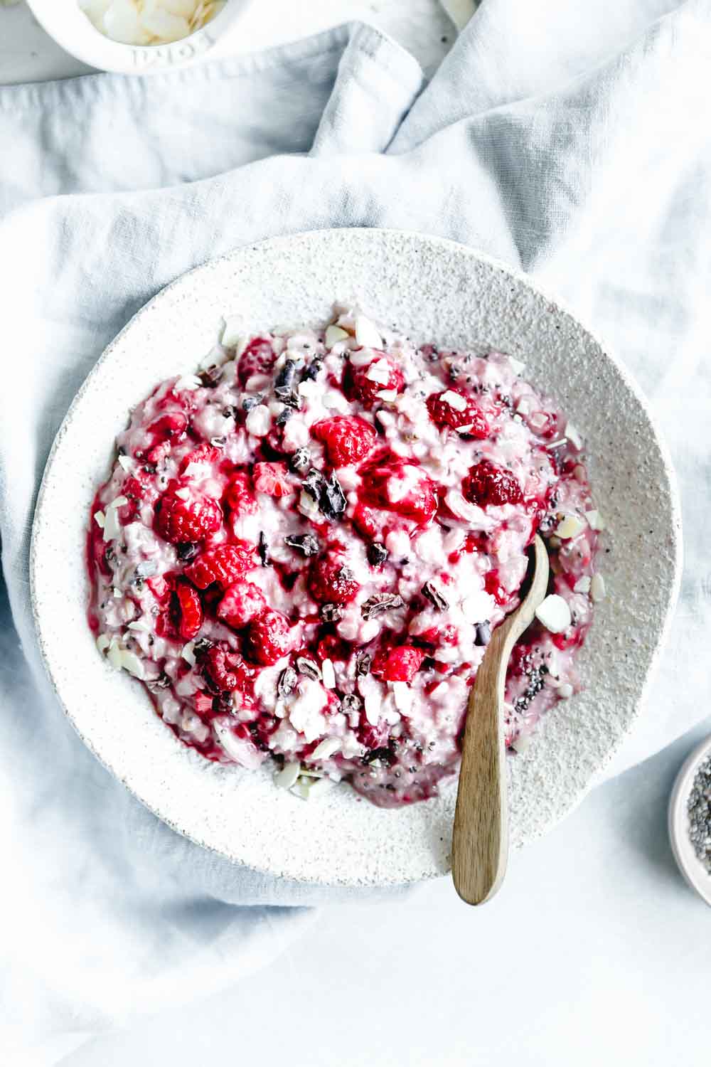 raspberry oats in bowl with wooden spoon