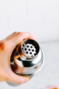 the top of a silver colored cocktail shaker showing the built-in sieve