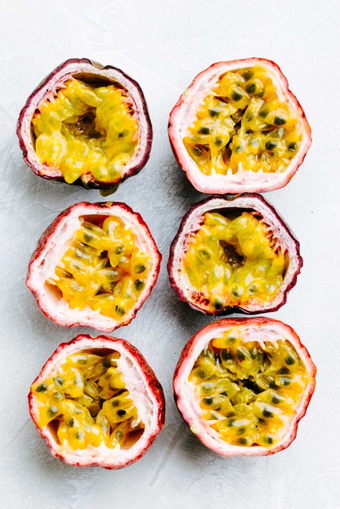 top view of passion fruits sliced open in half to show the yellow inside with seeds and pulp