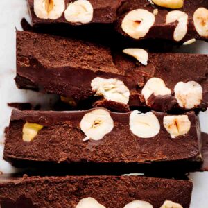 a row of brown colored chocolate slices with hazelnuts chunks showing on the inside of the slices.